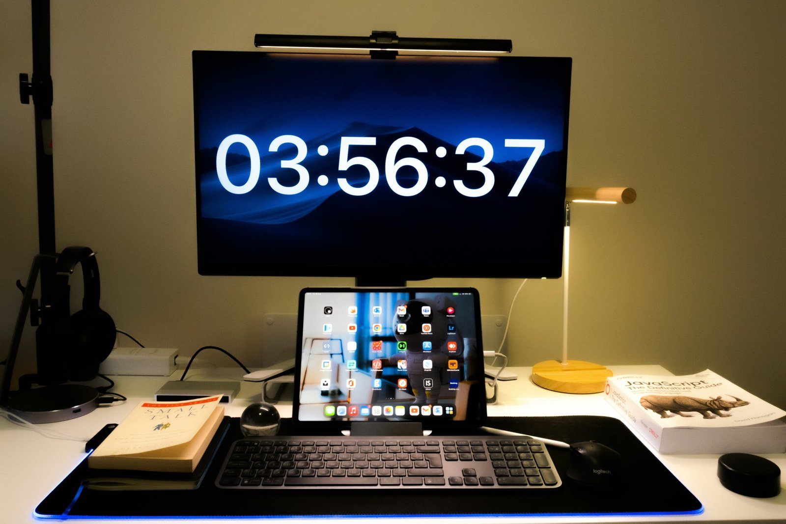 A smart clock sitting on a desk next to a laptop.