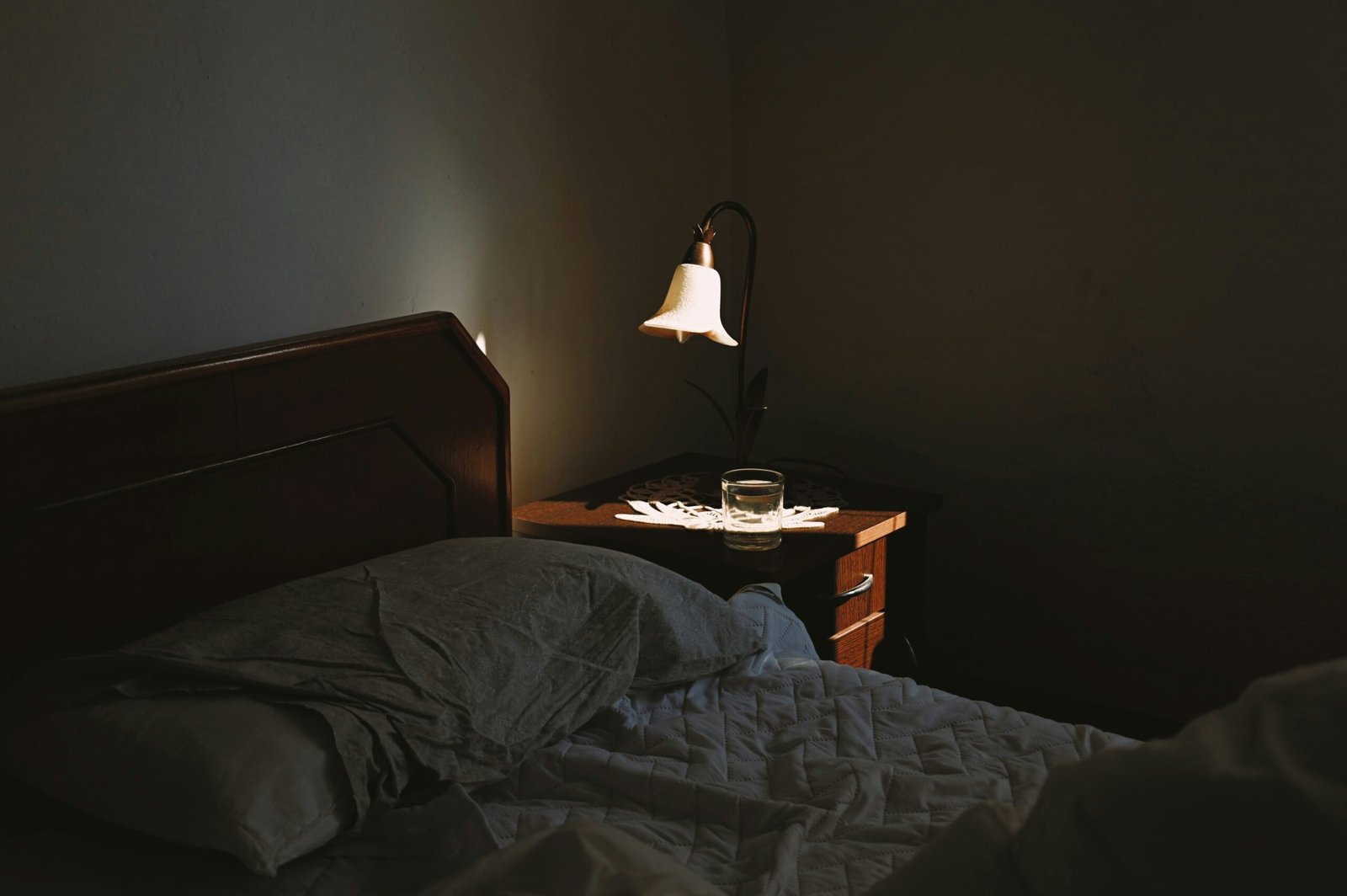 A smart clock sitting on a nightstand, glowing softly next to a cup of coffee.